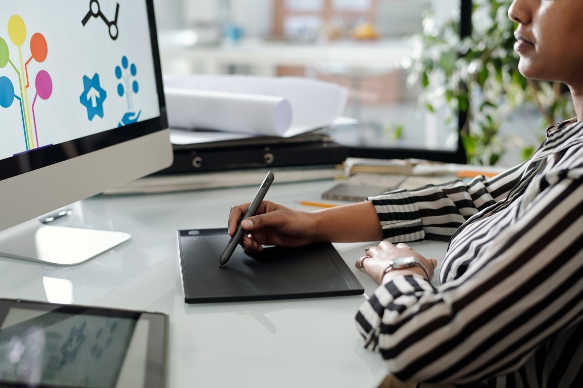 Hand of young african american graphic designer with stylus and touchpad
